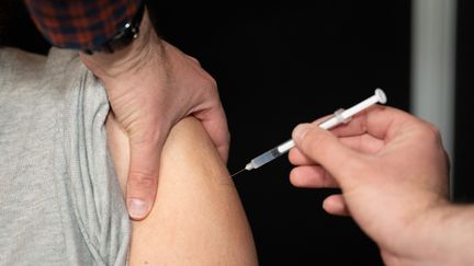 Une personne reçoit une dose de vaccin contre le Covid-19, à Champigny-sur-Marne (Val-de-Marne),&nbsp;le 13 avril 2022. (ALINE MORCILLO / HANS LUCAS / AFP)