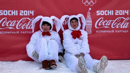 De jeunes h&ocirc;tesses se reposent apr&egrave;s avoir salu&eacute; le passage de la flamme olympique &agrave;&nbsp;Ekaterinbourg (Russie), le 13 d&eacute;cembre 2013. (SOCHI 2014 / AFP)