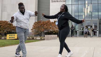 Deux militants appelant à la mobilisation dans les urnes dansent devant un bureau de vote situé sur le campus de l'université de Wayne State, à Detroit, dans le Michigan, mardi 5 novembre. (SARAH RICE / GETTY IMAGES NORTH AMERICA)