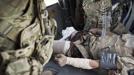 A l’intérieur de l’hélicoptère, le soldat reçoit immédiatement les premiers soins. (AFP PHOTO / BEHROUZ MEHRI )