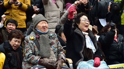 Elles protestent contre l'accord intervenu entre Séoul et Tokyo, présenté comme «historique», pour régler le différend sur celles qu'on appelait des «femmes de réconfort». Selon cet accord, le Japon a offert des «excuses sincères» et un milliard de yens (7,5 millions d'euros) aux 46 Sud-Coréennes, encore vivantes, qui furent il y a 70 ans contraintes de se prostituer pour les militaires japonais. Outrées, les femmes comme Lee Yong-Soo et Gil Won-Ok affirment vouloir se battre jusqu'à ce que le Japon endosse la responsabilité officielle des atrocités commises, afin de rendre justice aux victimes décédées. Salué par Washington, l'accord est dénoncé en revanche par la presse chinoise qui juge insuffisantes les excuses japonaises. (AFP PHOTO / JUNG YEON-JE  )