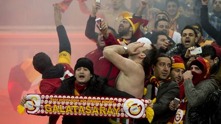 Des supporters du Galatasaray r&eacute;agissent au coup de sifflet final du match de l'UEFA opposant leur &eacute;quipe au Schalke 04 &agrave; Gelsenkirchen (Allemagne), le 12 mars 2013. (ODD ANDERSEN / AFP)