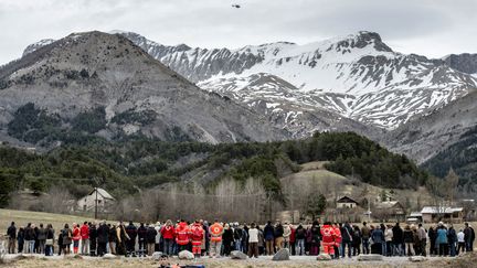 Des habitants et des membres de la Croix Rouge se recueillent devant une stèle en hommage aux victimes du crash de la Germanwings, au Vernet (Alpes-de-Haute-Provence), le 28 mars 2015. (JEFF PACHOUD / AFP)