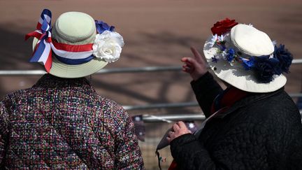 Des badauds discutent sur le bord du Mall, dans le centre de Londres, le 3 mai 2023, alors que les préparatifs se poursuivent en vue de la cérémonie de couronnement du roi Charles III, qui aura lieu le 6 mai. (DANIEL LEAL / AFP)