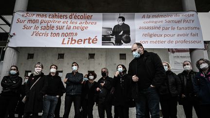 Des professeurs de lycée habillés en noir regardent une banderole qu'ils ont déployée en hommage au professeur d'histoire français assassiné Samuel Paty au lycée François-Magendie de Bordeaux le 2 octobre 2020. (PHILIPPE LOPEZ / POOL)