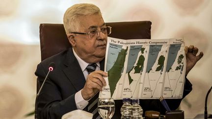 Le président palestinien, Mahmoud Abbas, tenant une carte de l'évolution des frontières des territoires palestiniens, le 1er février 2020, au Caire (Egypte). (KHALED DESOUKI / AFP)