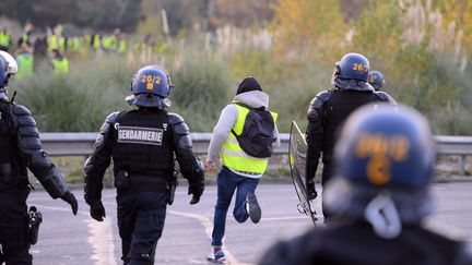 Un gilet jaune et des gendarmes à Bordeaux, le 19 novembre 2018. (NICOLAS TUCAT / AFP)