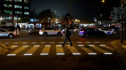 Un homme traverse à un passage piétons parisien, le 18 novembre 2021. (LUDOVIC MARIN / AFP)