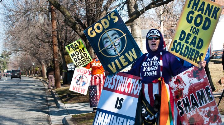 Deux membres de la Westboro Baptist Church manifestent lors de l'enterrement d'un soldat am&eacute;ricain, le 1er mars 2011 &agrave; Hyattsville (Maryland). Sur une des affiches, ce message : "Priez pour que davantage de soldats meurent." (NICHOLAS KAMM / AFP)