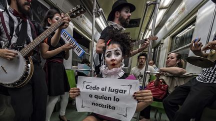 Une clown de la compagnie Claustrofobos, entourée de musiciens, invite les passager à "céder la place à ceux qui en ont besoin", le 31 mars 2015, à Mexico.
 (OMAR TORRES / AFP)