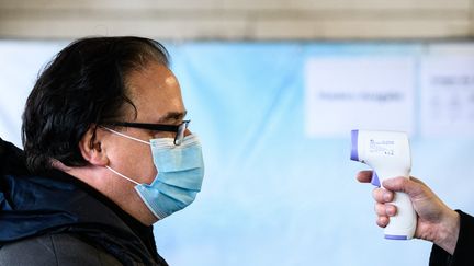 Un homme se fait prendre la température par un thermomètre sans contact, le 2 décembre 2020 à Mayence (Allemagne). (ANDREAS ARNOLD / DPA)