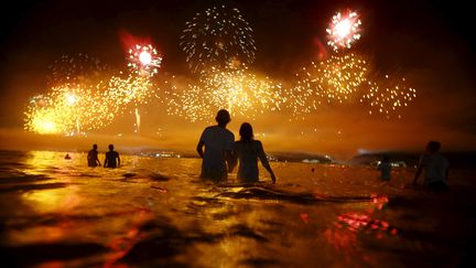 Les pieds dans l'eau et la tête dans les étoiles. Quoi de mieux qu'un feu d'artifice à Copacabana comme décor de réveillon ? Comme chaque année, des milliers de personnes se sont réunies sur la célèbre plage de Rio de Janeiro (Brésil). (? RICARDO MORAES / REUTERS / X02675)