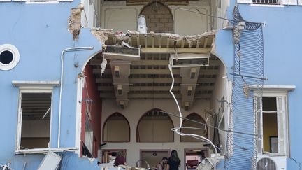 Un couple de Libanais contemple les dégâts dans leur habitation de Beyrouth, au lendemain de la double explosion qui a retenti dans le port de la capitale libanaise, mardi 4 août 2020. (JOSEPH EID / AFP)