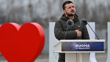 Le président ukrainien Volodymyr Zelensky assiste à une cérémonie marquant le premier anniversaire du retrait des troupes russes de la ville ukrainienne de Bucha, en Ukraine, le 31 mars 2023. (SERGEI SUPINSKY / AFP)