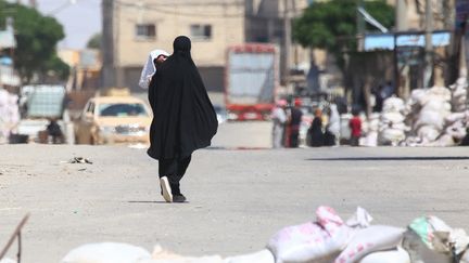 Une femme marche dans une rue de Tabqa, près de Raqqa, en Syrie, le 12 mai 2017. (DELIL SOULEIMAN / AFP)