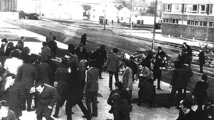 Des manifestants s'enfuient alors que des soldats britanniques tirent à balles réelles, le 30 janvier 1972, à Derry-Londonderry (Irlande du Nord, Royaume-Uni). (CIARAN DONNELLY / COURTESY MUSEUM OF FREE DERRY)