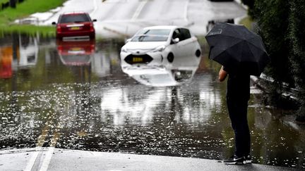 Des voitures bloquées dans les eaux de crue en raison de fortes pluies dans la banlieue sud-ouest de Sydney, en Australie, le 8 mars 2022. (MUHAMMAD FAROOQ / AFP)