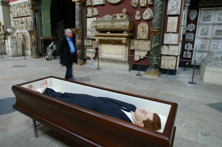 Une oeuvre de l'artiste italien Maurizio Cattelan, représentant un cercueil contenant un mannequin en plastique à l'effigie du président américain assassiné John Fitzgerald Kennedy, dans la Chapelle des Petits-Augustins, le 20 octobre 2004 à Paris, dans le cadre d'une exposition à l'Ecole nationale des Beaux-Arts.&nbsp; (PASCAL PAVANI / AFP)