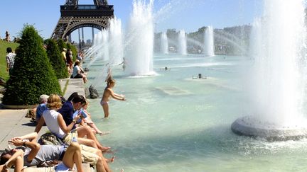 Des touristes bronzent sur l'esplanade du Trocad&eacute;ro le 23 juillet 2012 &agrave; Paris, alors que les temp&eacute;ratures ont atteint 28&deg;C dans la capitale. (ALFRED / SIPA)