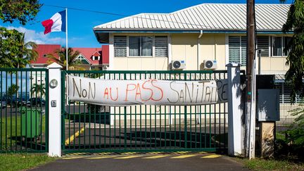 Une banderole&nbsp;contre le pass sanitaire accrochée au portail d'une caserne de pompiers à Petit-Bourg, en Guadeloupe, le 21 novembre 2021. (LARA BALAIS / AFP)