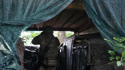 Un soldat ukrainien scrute les positions de l'armée russe dans la région de Kharkiv, en juillet 2023. (SERGEY BOBOK / AFP)