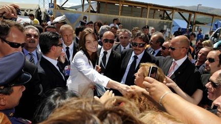 Carla Bruni-Sarkozy lors de sa visite dans un quartier de la ville d'Aquila, ravagé par un séisme le 6 avril 2009 (© AFP PHOTO / POOL / PHILIPPE WOJAZER)