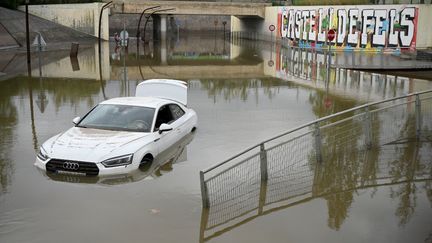 Une voiture sur une voie inondée à Castelldefels, en banlieue de Barcelone (Espagne), le 4 novembre 2024. (JOSEP LAGO / AFP)