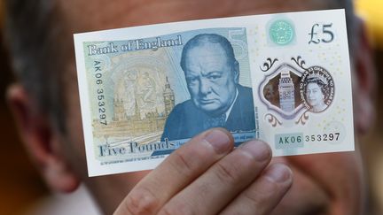 Un billet de cinq livres&nbsp;à l'effigie de l'ancien Premier ministre britannique Winston Churchill, entré en circulation en septembre 2016.&nbsp; (STEFAN WERMUTH / AFP)