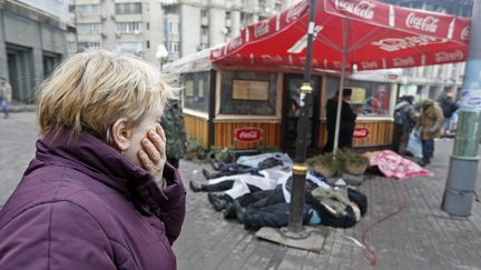 Une femme pleure en voyant des corps de manifestants tu&eacute;s lors des affrontements. ( VASILY FEDOSENKO / REUTERS)