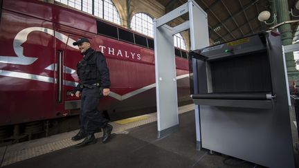 Un policier marche devant un train Thalys à Paris, le 17 novembre 2015. (IAN LANGSDON / EPA)