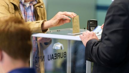 Un électeur glisse son bulletin dans l'urne, le 12 juin 2022 à Lille (Nord). (SYLVAIN LEFEVRE / HANS LUCAS / AFP)