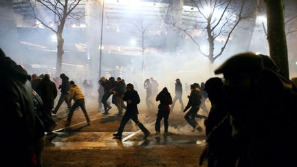 Des supporteurs du PSG sous les jets de gaz lacrymog&egrave;nes de la police, aux abords du parc des Princes, le 28 f&eacute;vrier 2010, en marge d'un match PSG-OM. (LOIC VENANCE / AFP)