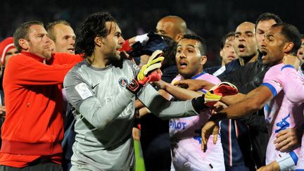 Le gardien parisien Salvatore Sirigu, aux prises avec des joueurs d'Evian, est retenu par des co&eacute;quipiers, le 28 avril 2013, &agrave; Evian (Haute-Savoie). (JEAN-PIERRE CLATOT / AFP)