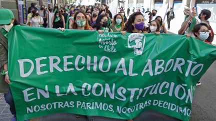 Des femmes tiennent une banderole indiquant "Le droit à l'avortement dans la Constitution" lors d'une manifestation devant l'ancien Congrès national, à Santiago, au Chili, le 28 septembre 2021. (PABLO VERA / AFP)