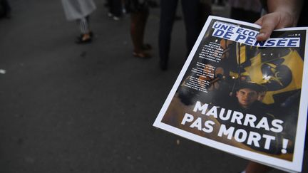 Un militant de l'Action française distribue un exemplaire du magazine du mouvement, le 21 juin 2018 à Paris. (ALAIN JOCARD / AFP)