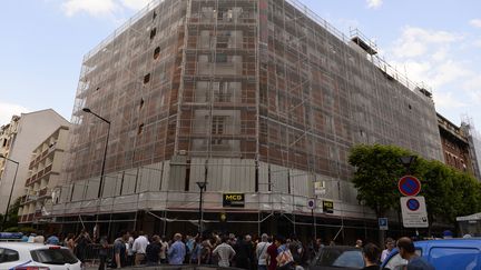 Des habitants sont r&eacute;unis devant l'immeuble d'Aubervilliers (Seine-Saint-Denis), qui a &eacute;t&eacute; partiellement d&eacute;truit par un incendie, samedi 7 juin. (ALAIN JOCARD / AFP)