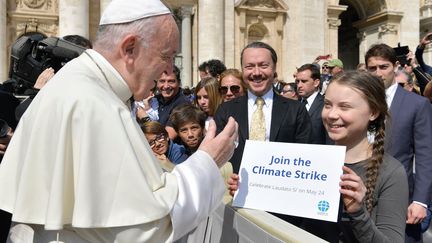 Au Vatican, Greta Thunberg rencontre brièvement le pape François, le 17 avril 2019, lors d'une audience générale sur la place Saint-Pierre. Ce dernier l'a "remerciée et encouragée pour son engagement en faveur de la défense de l'environnement", selon le porte-parole du Vatican, tandis que la militante a elle aussi remercié le pape "pour ses efforts en faveur de la défense" de la planète avec son encyclique "Laudato si'" consacrée à ce thème. (VATICAN MEDIA / AFP)