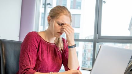 Une salariée stressée face à son ordinateur. Photo d'illustration. (CHRISTIN KLOSE / DPA-TMN)