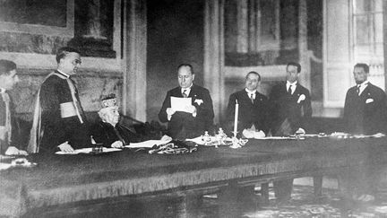 Accords de Latran. Le 11 février 1929. Benito Mussolini lisant le pacte après sa signature. Assis le Cardinal Gasparri, secrétaire d'Etat du Vatican, au Palais du Latran, à Rome. (KEYSTONE-FRANCE / GAMMA-KEYSTONE / GETTY IMAGES)