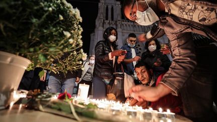 Des Niçois allument des bougies devant la basilique Notre-Dame en signe de recueillement après l'attentat, le 29 octobre 2020. (VALERY HACHE / AFP)