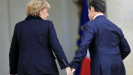 Le pr&eacute;sident fran&ccedil;ais Nicolas Sarkozy (D) et la chanceli&egrave;re allemande Angela Merkel p&eacute;n&egrave;trent dans le palais de l'Elys&eacute;e &agrave; Paris, le 5 d&eacute;cembre 2011. (CHARLES PLATIAU / REUTERS)