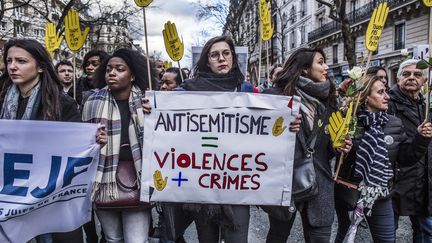 Des manifestants participent, le 28 mars 2018 à Paris, à une marche blanche en mémoire de Mireille Knoll, une retraitée juive&nbsp;tuée le 23 mars. (YANN CASTANIER / AFP)