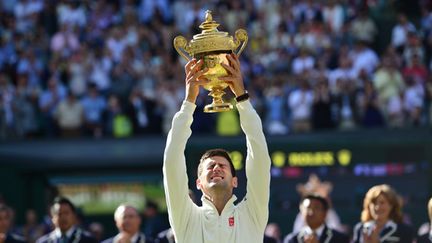 Novak Djokovic soulève le trophée de Wimbledon (CARL COURT / AFP)