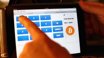 Un patron de pub utilise un iPad pour encaisser le paiement de ses clients en bitcoins, le 19 septembre 2013 &agrave; Sydney (Australie). (CAMERON SPENCER / GETTY IMAGES)