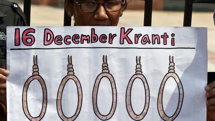 Une Indienne tient une pancarte demandant la peine de mort pour les quatre hommes accus&eacute;s du viol et du meurtre d'une &eacute;tudiante &agrave; New Delhi (Inde), le 11 septembre 2013. (MANAN VATSYAYANA / AFP)