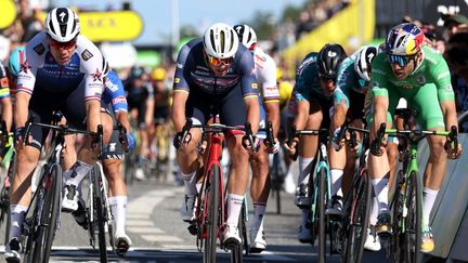 Sur la ligne, Fabio Jakobsen (à gauche) coiffe Mads Pedersen et Wout van Aert (à droite) au sprint lors de la 2e étape du Tour de France 2022, le 2 juillet 2022. (THOMAS SAMSON / AFP)