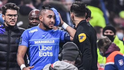 Dimitri Payet, touché à la tête après le jet d'une bouteille en plastique venue des tribunes du Groupama Stadium, lors du match Lyon-Marseille, le 21 novembre 2021. (PHILIPPE DESMAZES / AFP)
