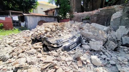 Une voiture&nbsp;détruite&nbsp;dans la ville de Vigan, dans le nord des Philippines, le 27 juillet 2022, après le tremblement de terre de magnitude 7 qui a frappé le pays. (RICARDO RAGUINI / AFP)