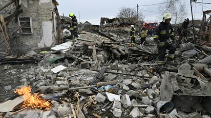 Des pompiers dans les décombres de maisons bombardées de la banlieue de Kiev (Ukraine), le 29 décembre 2022. (GENYA SAVILOV / AFP)