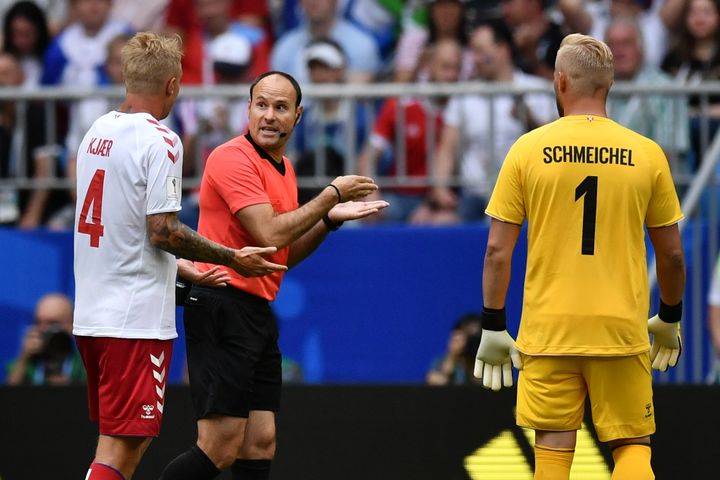 Les Danois Kasper Schmeichel&nbsp;et Simon Kjaer&nbsp;discutent avec l'arbitre espagnol&nbsp;Antonio Mateu Lahoz, qui doit consulter l'assistance vidéo, le 21 juin à Samara, en Russie. (FABRICE COFFRINI / AFP)